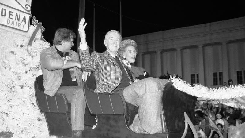 Actor Jimmy Stewart waves as he rides down Sunset Boulevard in the annual Christmas parade in Hollywood, Los Angeles on Nov. 30, 1986. At right is Stewart’s wife, Gloria, and left is actor Gil Gerald.