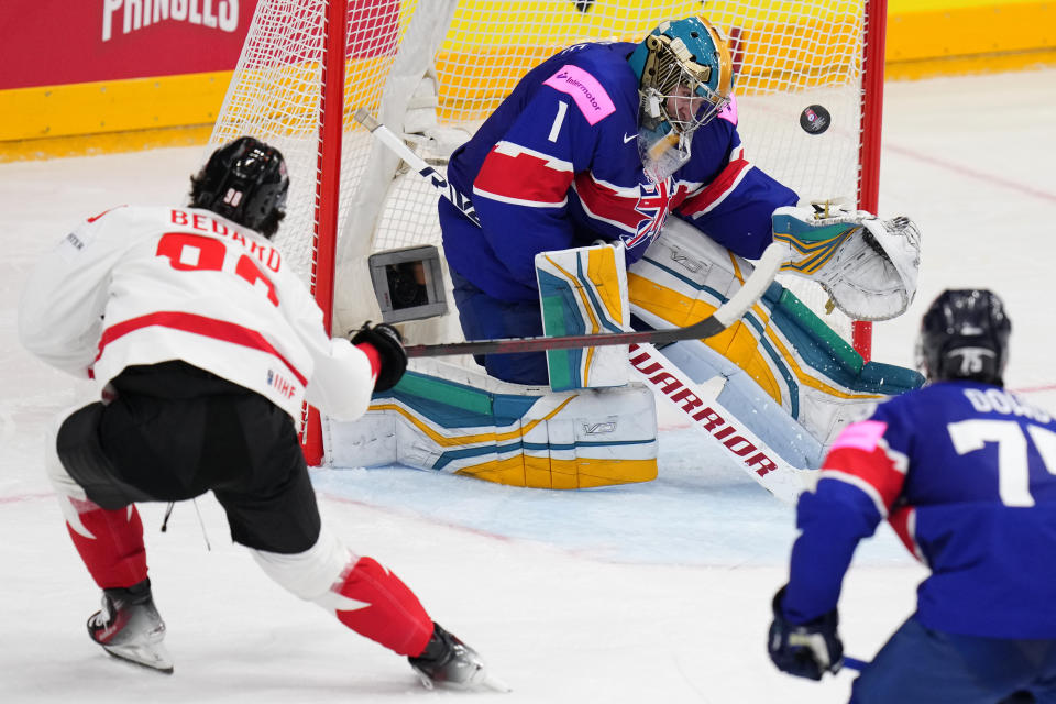 Canada's Connor Bedard, left, shoots to score his sides third goal past Britain's goalkeeper Jackson Whistle during the preliminary round match between Great Britain and Canada at the Ice Hockey World Championships in Prague, Czech Republic, Saturday, May 11, 2024. (AP Photo/Petr David Josek)