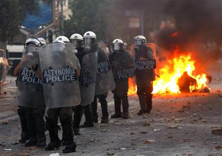 Riot police stand guard outside a police station during clashes between police and angry anti-fascist protesters following the killing of anti-racism rapper Pavlos "Killah P" Fissas, 35, by a man who sympathized with the far-right Golden Dawn group, in an Athens suburb September 18, 2013. REUTERS/Yannis Behrakis