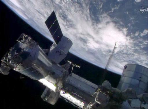 Foto del 20 de abril de 2014 difundida por la NASA TV muestra a la cápsula privada SpaceX Dragon acoplada a la estación espacial ISS con la Tierra como fondo. (NASA TV/AFP | HANDOUT)