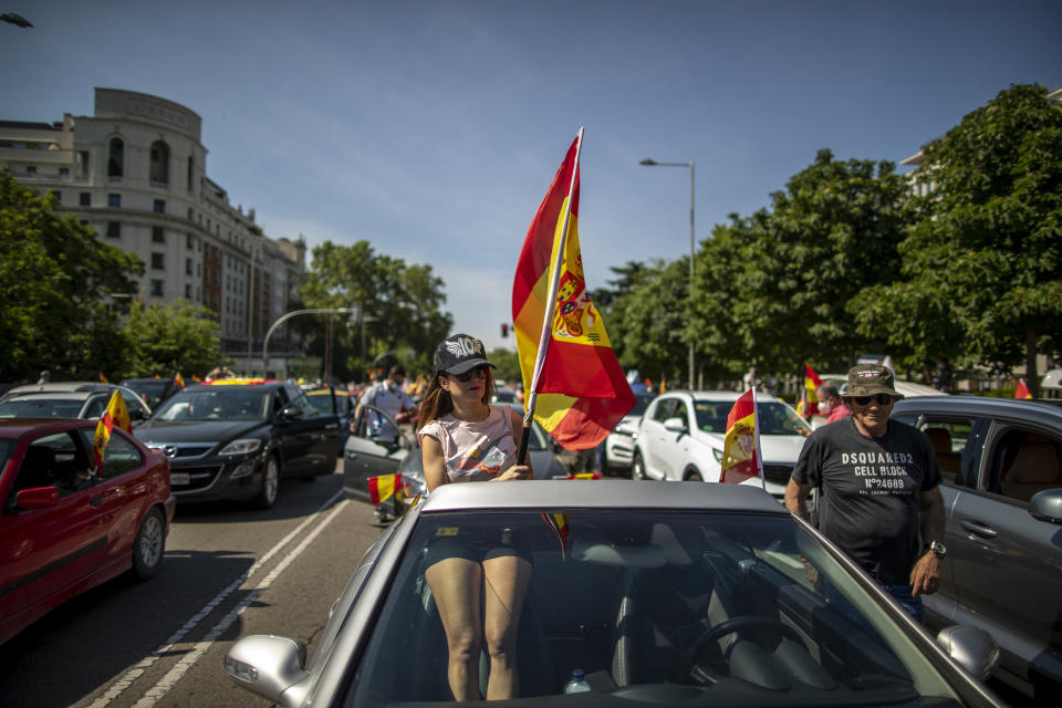A woman waves a Spanish flag during a drive-in protest organised by Spain's far-right Vox party against the Spanish government's handling of the nation's coronavirus outbreak in Madrid, Spain Saturday, May 23, 2020. (AP Photo/Manu Fernandez)