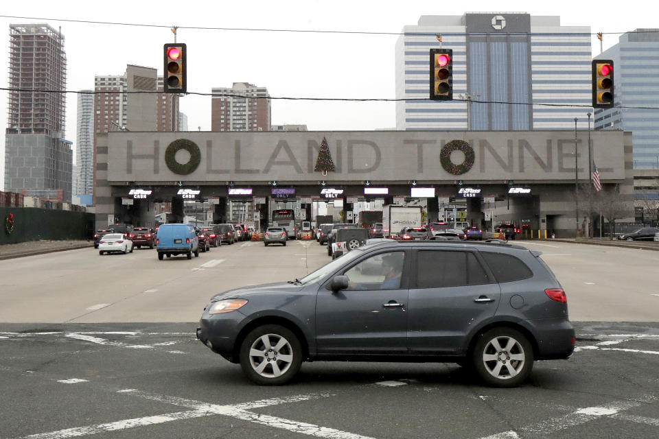 FILE - In a Thursday, Dec. 13, 2018 file photo, holiday decorations adorn the letters on the toll booth structure on the Holland Tunnel approach, in Jersey City. Motorists complained that the decorations don't look right. More than 21,000 people voted in a poll commissioned by tunnel operator the Port Authority of New York and New Jersey. Poll numbers were released Monday, Dec. 17. The consensus? Move the tree from over the “N” in “Holland” to over the “A,” and remove a wreath hanging over the “U.” (AP Photo/Julio Cortez, File) (AP Photo/Julio Cortez, File)