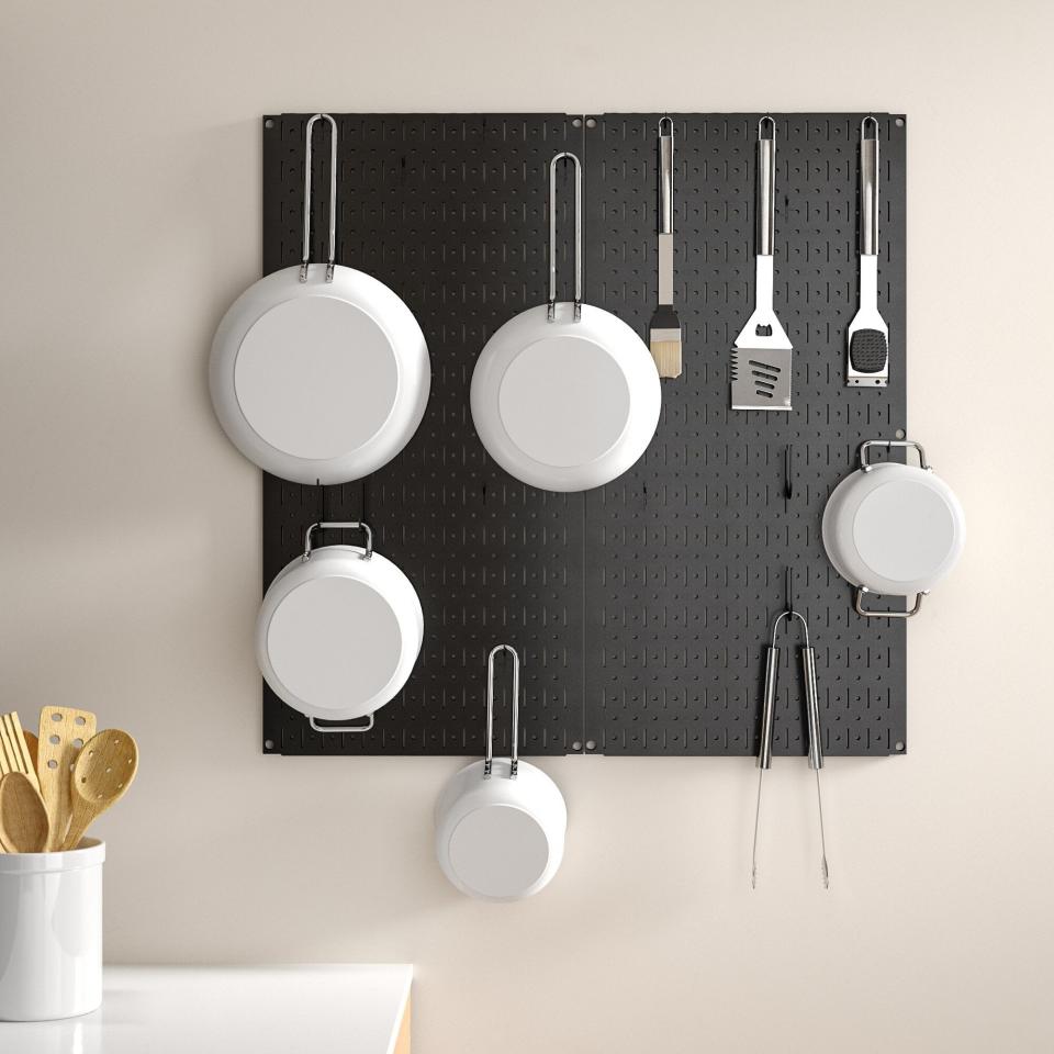 black pegboard with pots and pans hanging