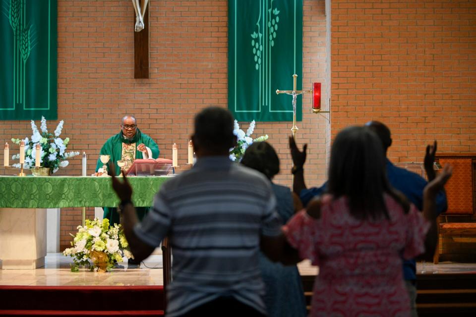 Parishioners stand in Our Lady of Grace Catholic Church in Reserve, La., during a sermon by the Rev. Christopher Chike Amadi.