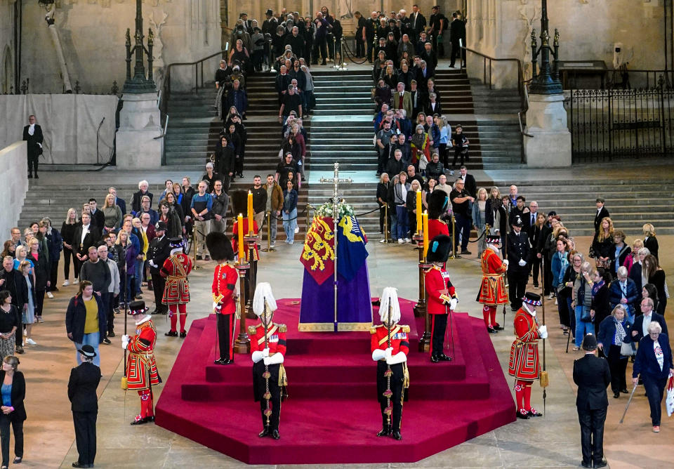 People file past the coffin of Queen Elizabeth II, draped in the Royal Standard with the Imperial State Crown and the Sovereign's orb and scepter, lying in state on the catafalque in Westminster Hall on Sept. 15, 2022, in London. (Yui Mok / AFP - Getty Images)