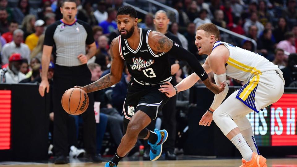 Feb 14, 2023; Los Angeles, California, USA; Los Angeles Clippers forward Paul George (13) moves to the basket against Golden State Warriors guard Donte DiVincenzo (0) during the first half at Crypto.com Arena.