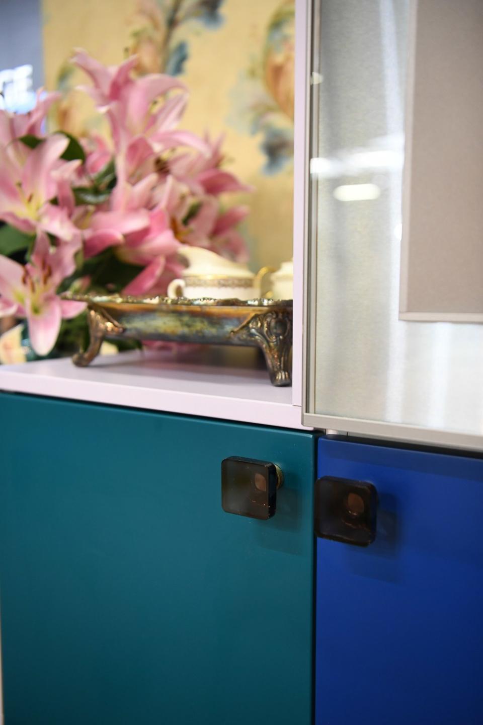 Gray glass knobs by Emtek complemented the tones of the custom cabinet by Reform.