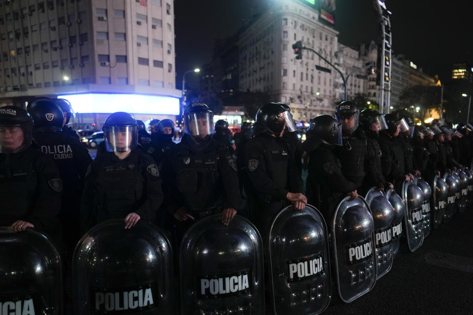Police stand in riot gear near a protest at the Obelisk in Buenos Aires, Argentina, Thursday, Aug. 10, 2023. As police tried to disperse the protest that had been called by several left-wing groups, a man died of a heart attack while police were detaining him. (AP Photo/Natacha Pisarenko)