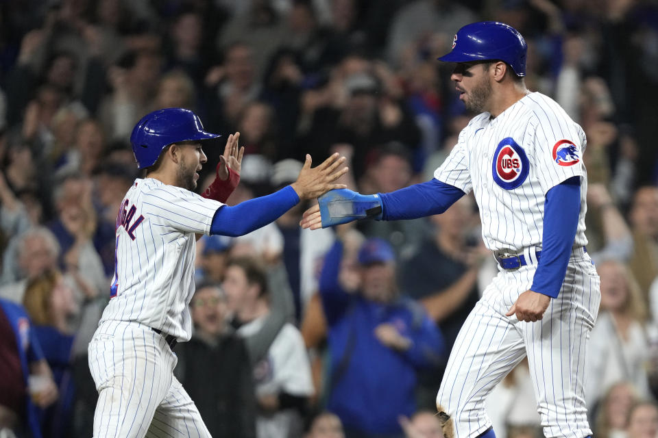 Chicago Cubs' Nick Madrigal, left, and Mike Tauchman celebrate after they scored on Ian Happ's two-run single against the Pittsburgh Pirates during the sixth inning a baseball game Wednesday, June 14, 2023, in Chicago. (AP Photo/Charles Rex Arbogast)