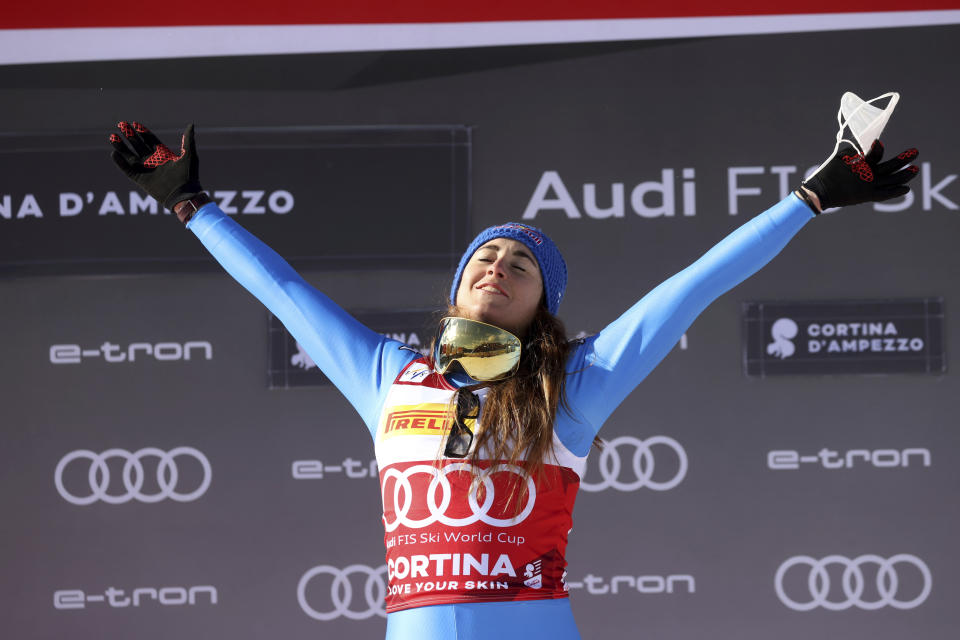 Italy's Sofia Goggia celebrates on the podium after winning the alpine ski, women's World Cup downhill, in Cortina d'Ampezzo, Italy, Saturday, Jan. 22, 2022. (AP Photo/Alessandro Trovati)