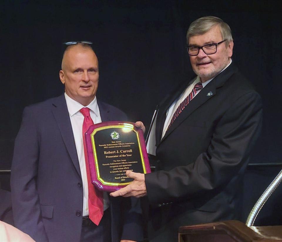 Morris County Prosecutor Robert Carroll, right, is presented with the Prosecutor of the Year award by George Snowden, second vice president of the New Jersey Narcotics Enforcement Officers Association, at the association's awards luncheon in Atlantic City Thursday, June 15, 2023.