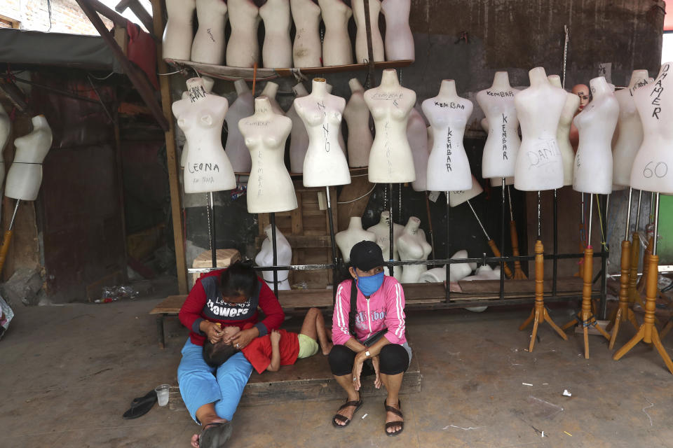 In this Thursday, April 30, 2020, photo, Indonesian women sit among mannequins at Tanah Abang textile market that is closed due to the new coronavirus outbreak in Jakarta, Indonesia. May Day usually brings both protest rallies and celebrations rallies marking international Labor Day. This year it's a bitter reminder of how much has been lost for the millions left idle or thrown out of work due to the coronavirus pandemic. Garment workers in Asia are among the hardest hit as orders dry up and shutdowns leave factories shuttered. (AP Photo/Tatan Syuflana)