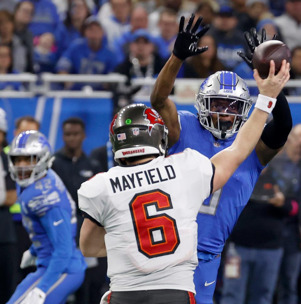 Tampa Bay Buccaneers quarterback Baker Mayfield just barely gets the ball past the outstretched arms of Detroit Lions safety Ifeatu Melifonwu.