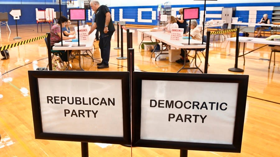 A voter checks in at Suffield Middle School on primary election day, Tuesday, Aug. 9, 2022, in Suffield, Conn. Suffield is one of several small towns in Connecticut where control was flipped from Democrats to Republicans in 2021 municipal races. (AP Photo/Jessica Hill)