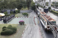 Police stand guard behind barbed wire and a row of large vehicles barricading the base entrance of the 11th Infantry Regiment, a palace security unit under direct command of the Thai king, as they await for the arrival of protesters Sunday, Nov. 29, 2020, in Bangkok, Thailand. Pro-democracy demonstrators are continuing their protests calling for the government to step down and reforms to the constitution and the monarchy, despite legal charges being filed against them and the possibility of violence from their opponents or a military crackdown. (AP Photo/Sakchai Lalit)