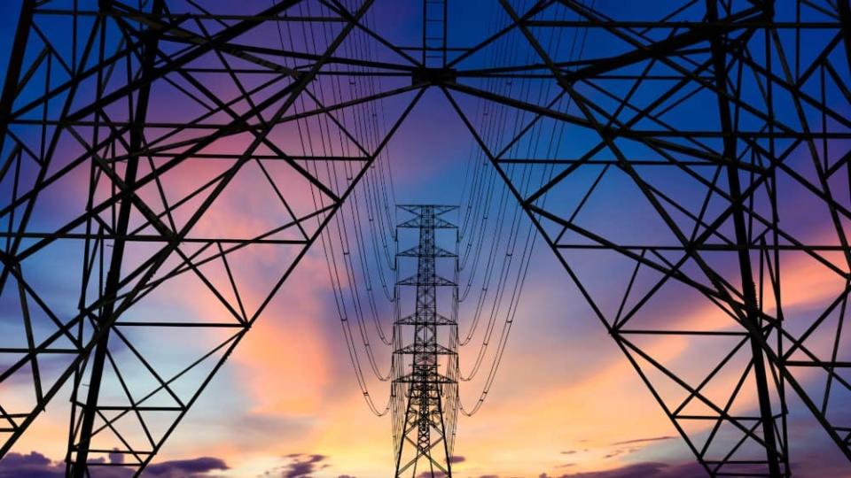 Electricity pylons against a sunset