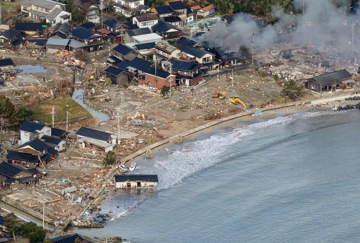 This aerial photo provided by Jiji Press shows smoke rising from a house fire along with other damage along the coast in the town of Noto, Ishikawa prefecture, on Jan. 2, 2024, a day after a major 7.5 magnitude earthquake struck the region.