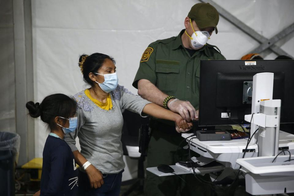 A migrant and her daughter have their biometric information entered at a Texas immigrant detention center in 2021. <a href="https://media.gettyimages.com/id/1232022951/photo/topshot-us-texas-border-immigration-detention.jpg?s=612x612&w=gi&k=20&c=0S_KzPxMiQEr4qn3baY5OH_LMolPLhMwb9H3j6wpXUY=" rel="nofollow noopener" target="_blank" data-ylk="slk:Dario Lopez-Mills/AFP via Getty Images;elm:context_link;itc:0;sec:content-canvas" class="link ">Dario Lopez-Mills/AFP via Getty Images</a>