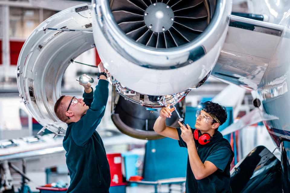 mechanics inspecting a jet engine