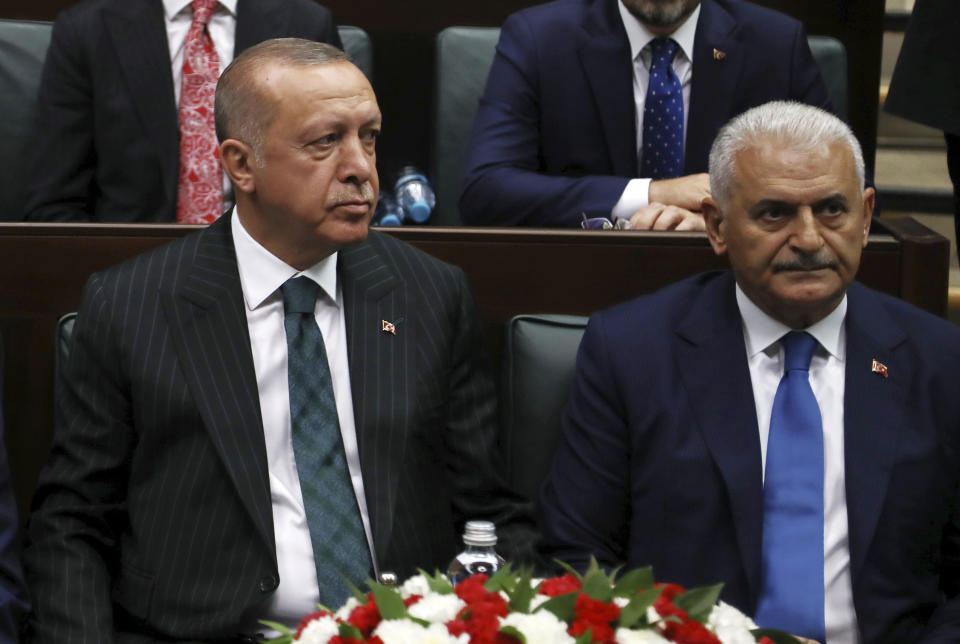 Turkey's President Recep Tayyip Erdogan, left, with Binali Yildirim, his mayoral candidate for Istanbul, attends parliament in Ankara, Turkey, Tuesday, June 25, 2019, two days after Ekrem Imamoglu, the candidate of the secular opposition Republican People's Party, won the election for mayor of Istanbul. Erdogan addressed his AK Party's weekly meeting, the first time he speaks since the Istanbul mayoral election Sunday, which was a big setback for him and his party. (AP Photo/Burhan Ozbilici)