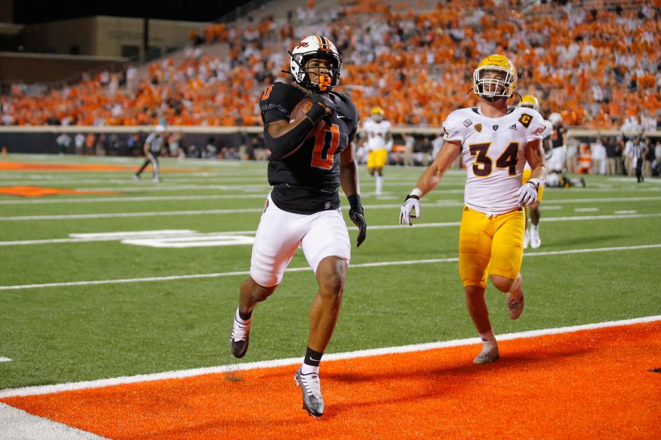 OSU running back Ollie Gordon (0) scores a touchdown beside Arizona State linebacker Kyle Soelle (34) during the Cowboys' 34-17 win on Saturday.