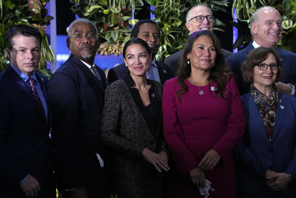 U.S. Rep. Alexandria Ocasio-Cortez, center, smiles as she poses for a photo with other US politicians at the venue of the COP26 U.N. Climate Summit in Glasgow, Scotland, Tuesday, Nov. 9, 2021. The U.N. climate summit in Glasgow has entered it's second week as leaders from around the world, are gathering in Scotland's biggest city, to lay out their vision for addressing the common challenge of global warming. (AP Photo/Alberto Pezzali)
