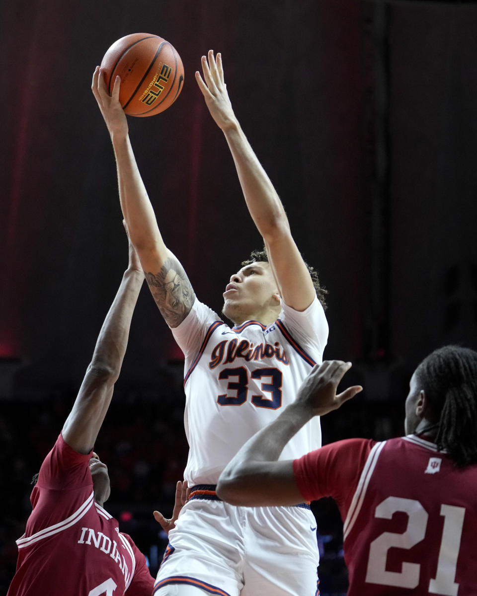 Illinois' Coleman Hawkins (33) drives to the basket between Indiana's Anthony Walker, left, and Mackenzie Mgbako during the first half of an NCAA college basketball game, Saturday, Jan. 27, 2024, in Champaign, Ill. (AP Photo/Charles Rex Arbogast)