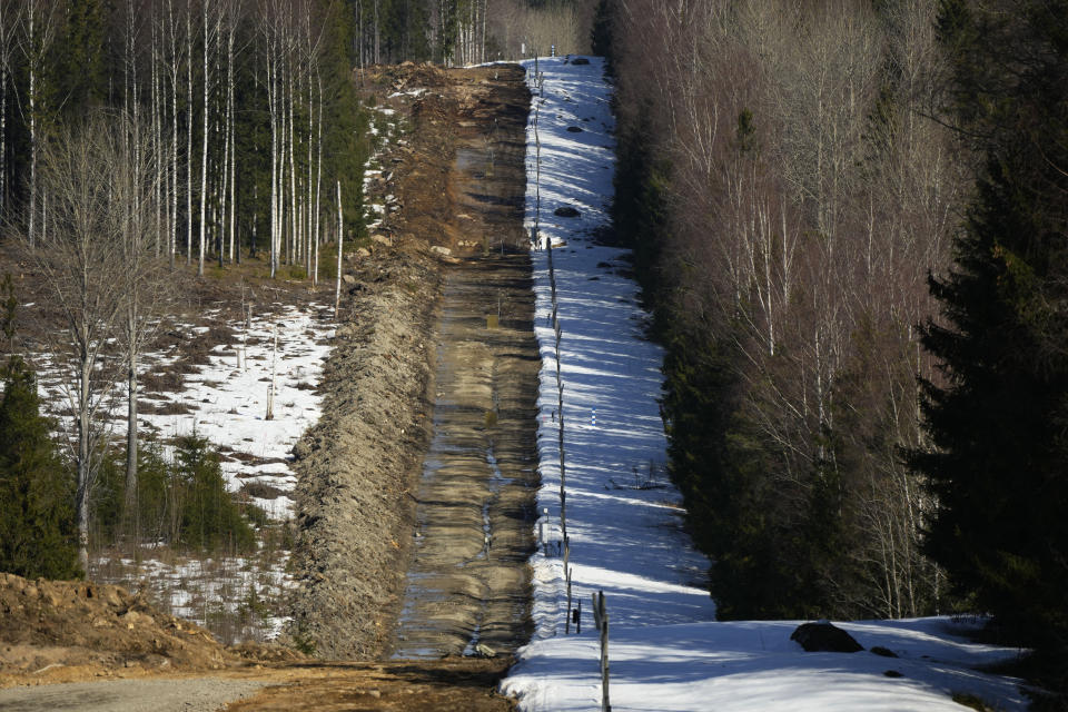 A border barrier fence between Finland, left, and Russia is seen in a forest near Pelkola border crossing point in Imatra, south-eastern Finland, Friday, April 14, 2023. (AP Photo/Sergei Grits)