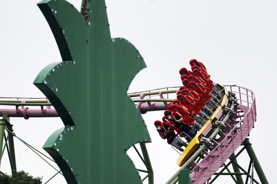 FILE - In this June 16, 2020, file photo, visitors ride the roller coaster at the reopened Yomiuriland amusement park in Tokyo following the closure since the end of March due to the new coronavirus. Japan’s economy is opening cautiously, with social-distancing restrictions amid the coronavirus pandemic. (AP Photo/Eugene Hoshiko, File)