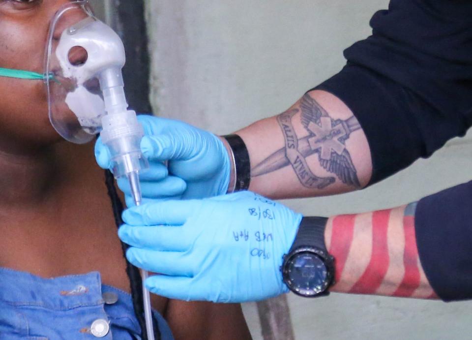 A paramedic gives a breathing treatment to an asthmatic patient.