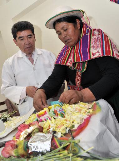 El director del Hospital Agromont, Jaime Agramont, (d) y curanderos indígenas realizan un ritual para llamar al "Ajayu" (espíritu) de un paciente, el 5 de diciembre de 2013 en El Alto, Bolivia (AFP | Aizar Raldes)
