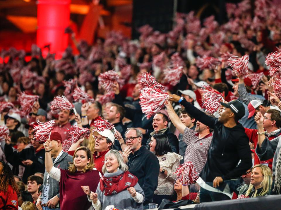 alabama football fans cheering in the stands at a game