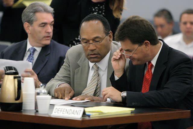 <p>Jae Hong-Pool/Getty</p> O.J. Simpson (center) and his attorneys Yale Galanter (right) and Gabriel Grasso (left) confer during the opening day of Simpson's trial at Clark County Regional Justice Center on Sept. 15, 2008 in Las Vegas