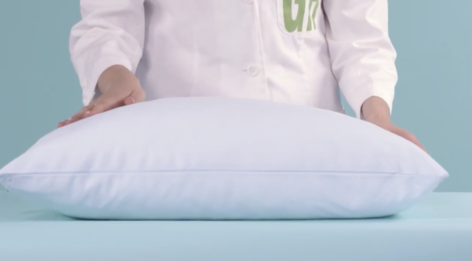 hands pushing on a slumber cloud cooling pillow, part of good housekeeping pillow testing