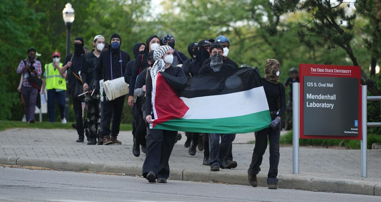 A small group with drums walks the outer perimeter of the protests at The Ohio State University on May 1 as demands are made for the university to divest from Israel over the Israel-Hamas war.