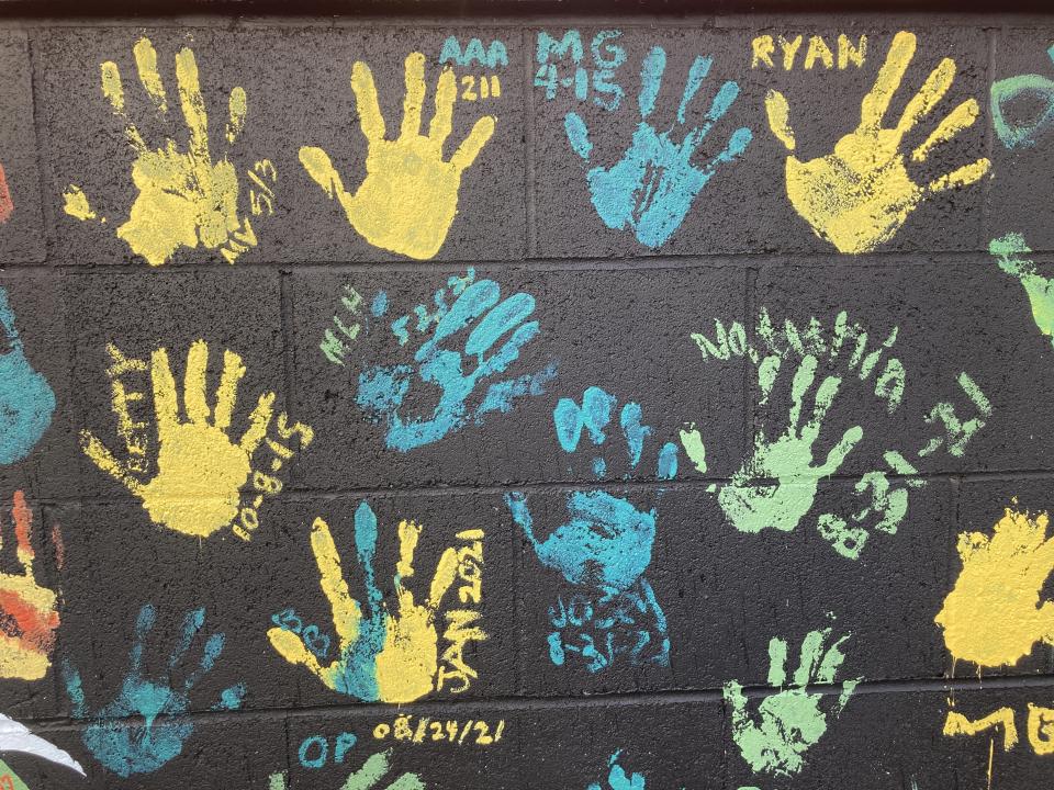 Some of the handprints of people recovering from drug addiction are seen on Dec. 9, 2021, on a wall in the parking lot of Provoking Hope, an addiction recovery center in McMinnville, Ore. Along with the handprints are the dates when they became "clean." McMinnville and thousands of other towns across the United States that were wracked by the opioid crisis are on the precipice of receiving billions of dollars in the second-biggest legal settlement in U.S. history. (AP Photo/Andrew Selsky)