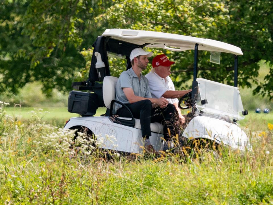 Former President Donald Trump drives a cart at Trump National Golf Club with his son Eric Trump at left, Monday, Sept. 12, 2022, in Sterling, Va.