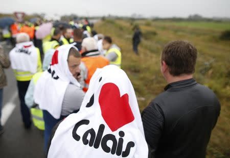 Harbor workers, storekeepers and residents march on the motorway to participate in a human chain protest demonstration against the migrant situation in Calais, France, September 5, 2016. REUTERS/Charles Platiau