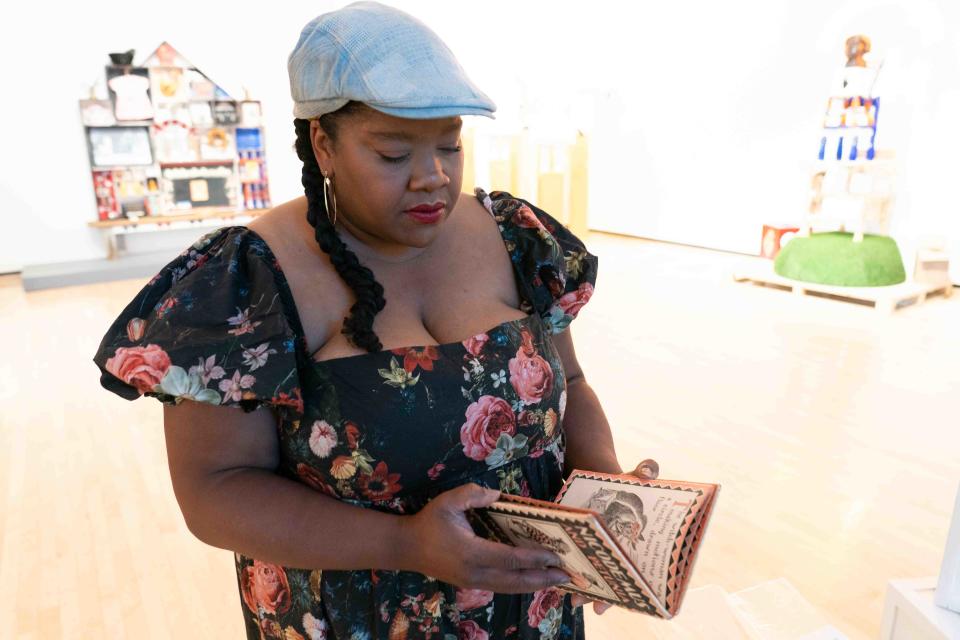 A copy of the book "Nicodemus and Petunia" is opened by artist vanessa german Tuesday as an object included in her exhibit "CRAVING LIGHT: The Museum of Love & Reckoning" at the Rita Blitt Gallery. "I think it's really important that you make something you love," german said.