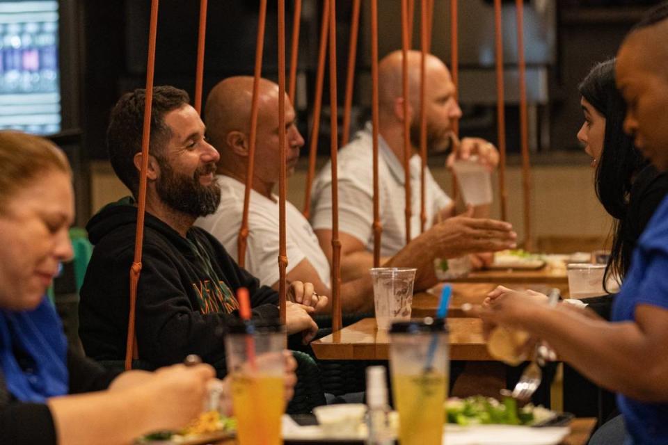 Customers dine at Shoma Bazaar food hall in Doral, which is expanding to Hialeah. The diners on the left are sitting on swings, one of the quirky touches in the food hall’s design.