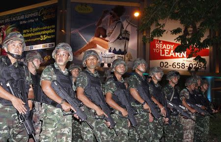 Soldiers hold their weapons as they guard a road in central Bangkok, a day after the Thai army chief seized power in a coup May 23, 2014. REUTERS/Erik De Castro