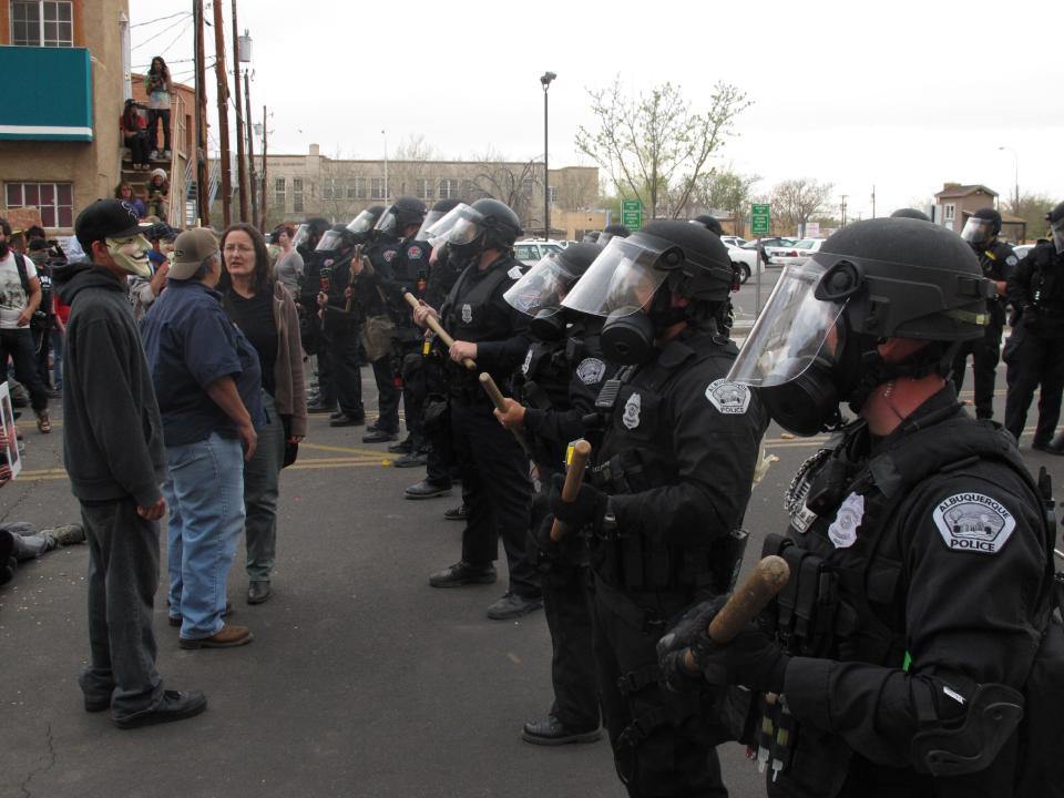Agentes de la Policía de Albuquerque frente a manifestantes el domingo 30 de marzo de 2014 en el centro de esa ciudad de Nuevo México durante una protesta contra recientes balaceras en que la policía ha intervenido. (Foto AP/Russell Contreras)