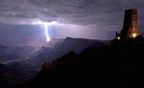 This is the incredible moment a fierce lightning bolt crashed against the Grand Canyon illuminating the steep canyon walls. Shrouded in darkness, the breath-taking landscape was shocked into life as mother nature sent the bolt storming down to Earth. As it cracked against the rocks the bright blue bolt illuminated the South Rim of the canyon, considered one of the Seven Natural Wonders of the World. With just the Desert View Watchtower in the foreground, the lightning was perfectly framed by the canyon which is located in Arizona, USA. (Travis Roe/ U.S. Dept. of the Interior / Caters News)