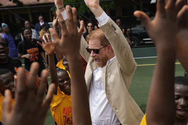 <p>AP Photo/Sunday Alamba</p> Prince Harry chants with children during the visit to Giants of Africa at Ilupeju Senior Grammar School on May 12, 2024 in Lagos, Nigeria.