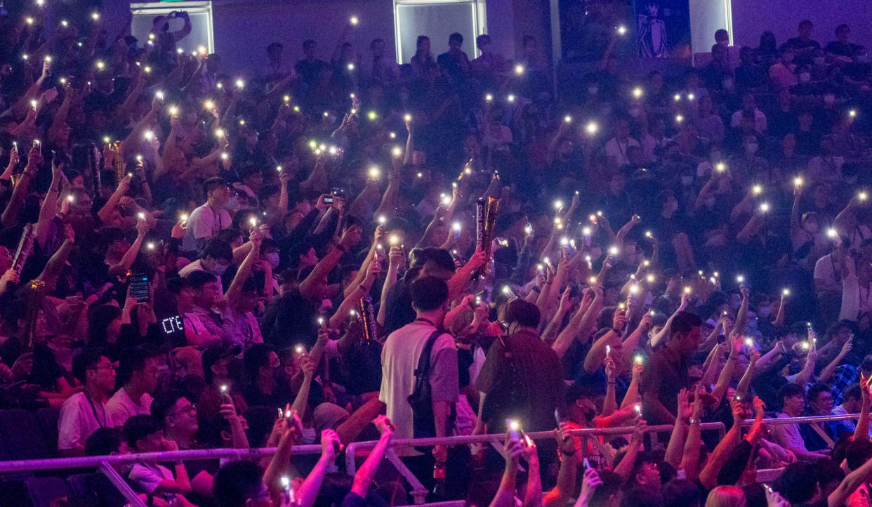 Live audience wave their phones in the air