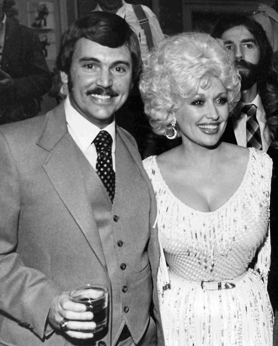 In this undated photo, Nashville, Tenn., newsman Joe Edwards, who has been writing the "Nashville Sound" column for nine years and knows everyone in the country music industry, poses with friend, actor and singer Dolly Parton at an awards reception. Edwards, who chronicled Tennessee news for more than 40 years as a newsman for The Associated Press and helped “Rocky Top” become a state song, died Friday, Feb. 3, 2023. He was 75. (AP Photo/Mark Humphrey)