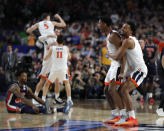 Virginia players celebrate at the end of a semifinal round game against Auburn in the Final Four NCAA college basketball tournament, Saturday, April 6, 2019, in Minneapolis. (AP Photo/Charlie Neibergall)