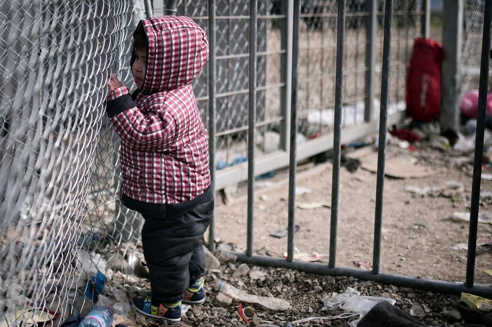 A child stands at a gate on the Greek-Macedonian border on March 3, 2016.