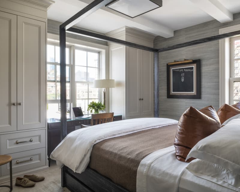 BEdroom with gray panel accent wall, desk area, 4 poster black bed frame