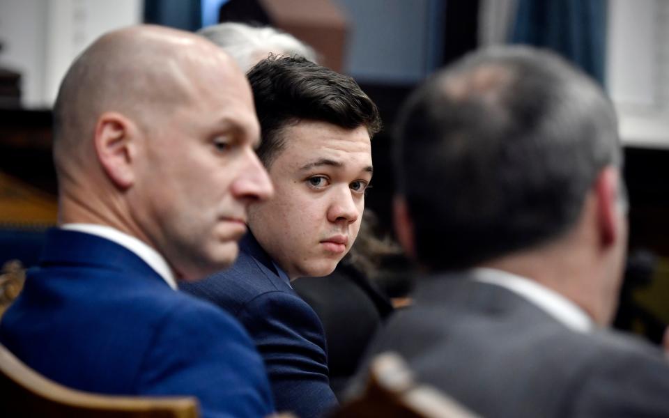 Kyle Rittenhouse, center, looks over to his attorneys as the jury is dismissed for the day during his trial at the Kenosha County Courthouse in Kenosha, Wis., on Thursday, Nov. 18, 2021.